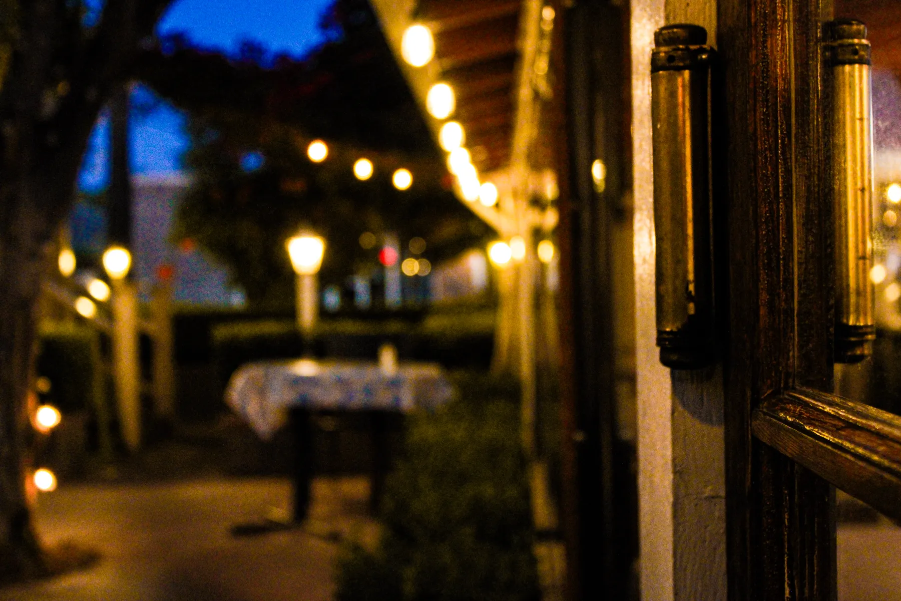 The patio after dark, string lights over a set table