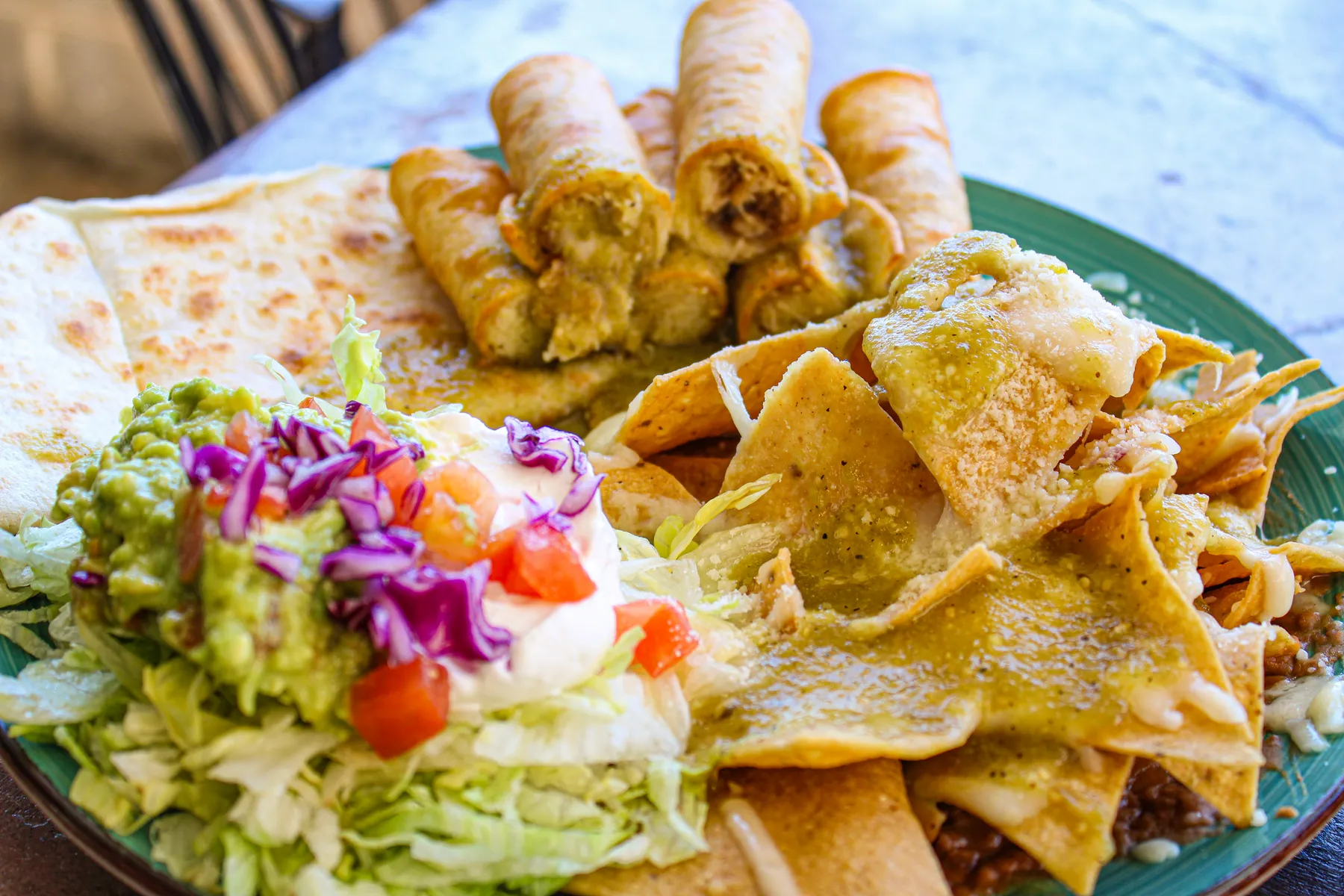 Platter of taquitos, nachos, guacamole and pico de gallo